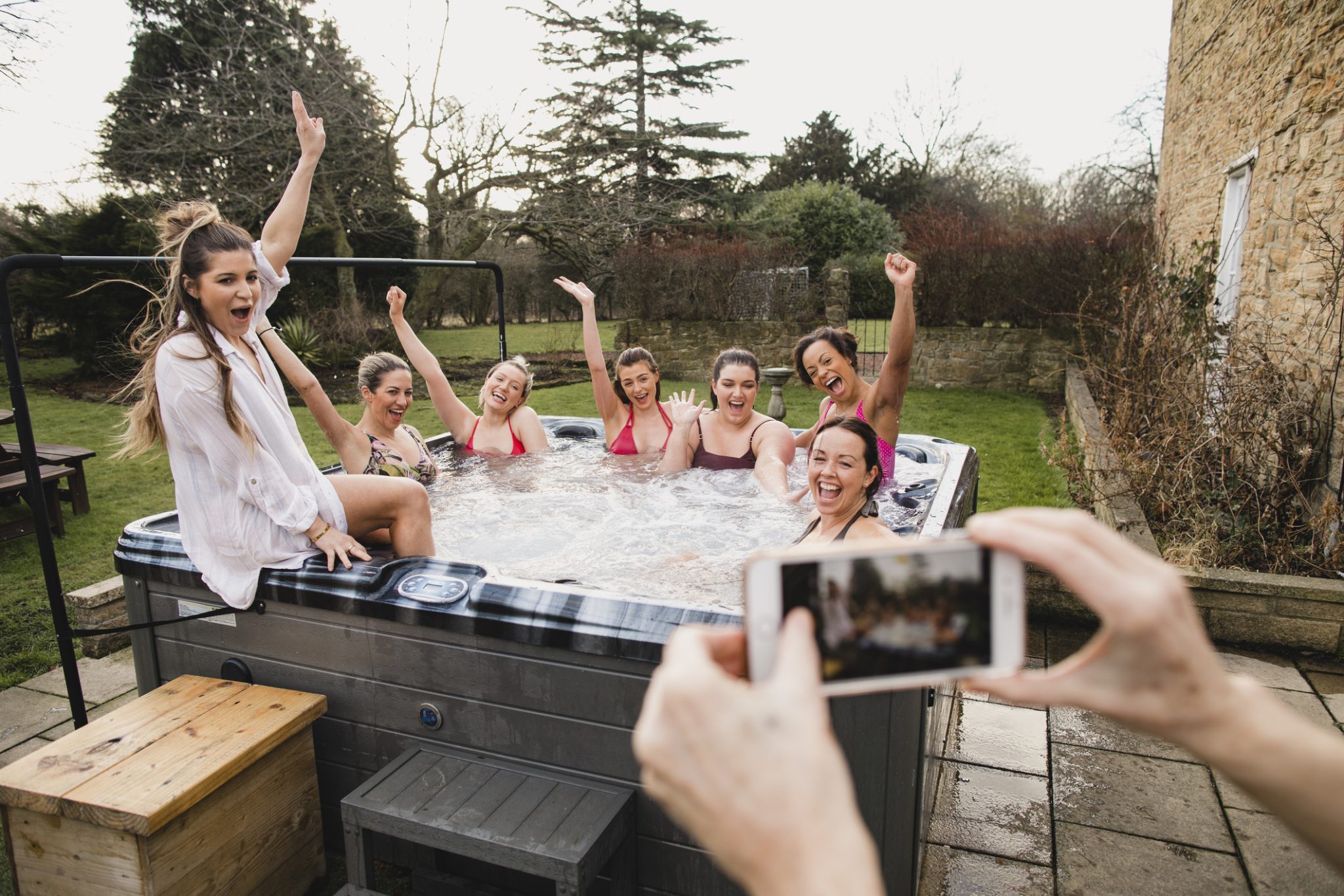 A group of friends enjoying a backyard hot tub after professional hot tub installation in Scottsdale, AZ.