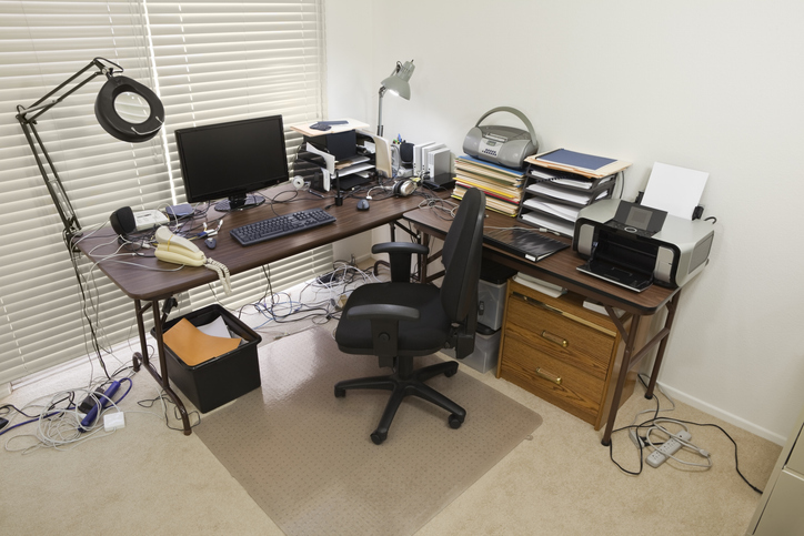 Chaotic space with many electronics and cords that could benefit from some major electrical upgrades for home office.