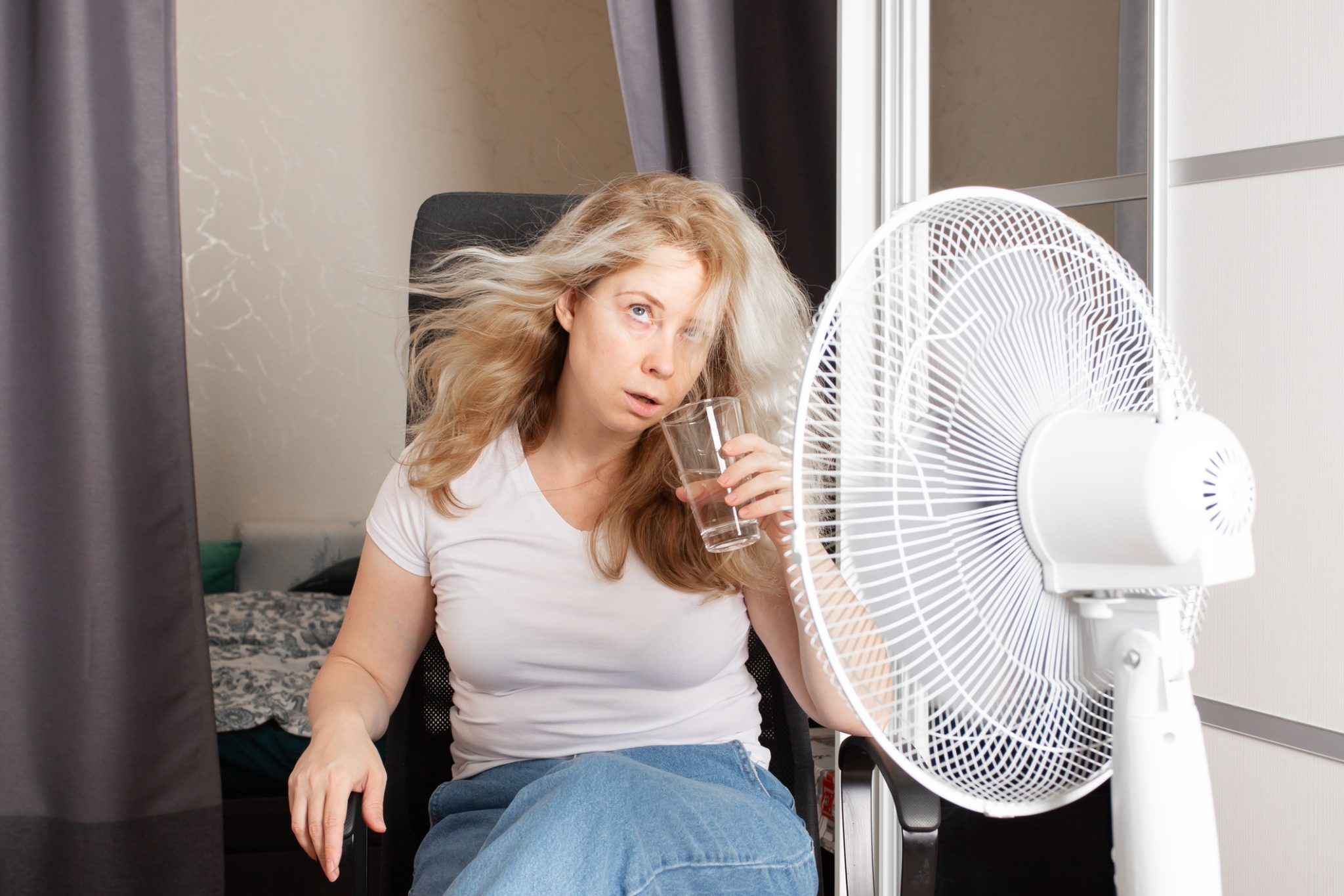Woman struggling in summer heat — Arizona electrical system problems can cause AC failure and residential power issues.